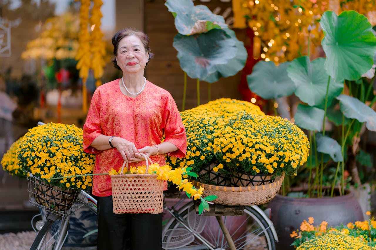 about-img elderly-woman-with-bicycle-and-yellow-chrysanthemums-34165320